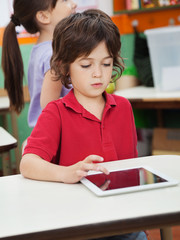 Little Boy Using Digital Tablet In Kindergarten