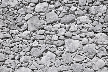 grey old wall made of big and little stones