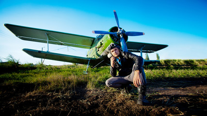 Pilot is sitting in front of vintage plane
