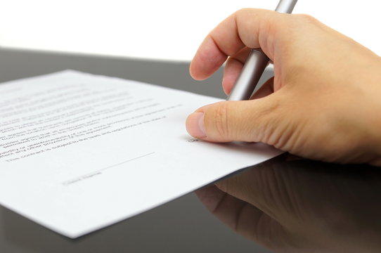 businessman examines the articles of agreement before signing