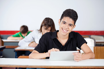 Male University Student Using Digital Tablet At Desk