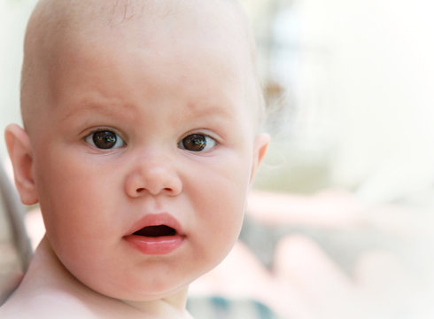 Closeup outdoor portrait of surprised Caucasian baby