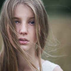 portrait of a beautiful blonde in a field in spring