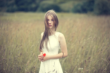 portrait of a beautiful young girl in a field in spring