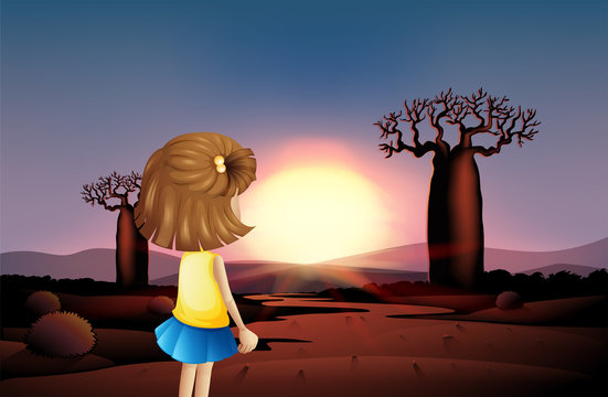 A young girl watching the sunset at the desert