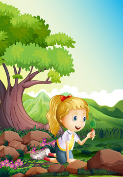 A girl at the forest holding a shovel