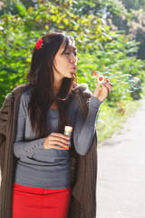 Fototapeta premium Young asian woman blowing soap bubbles in the park
