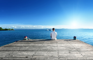 young man relax siting on pier