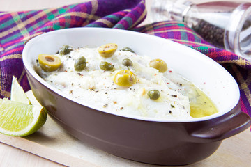 Baked filet of white fish Dorado with olives, capers, olive oil