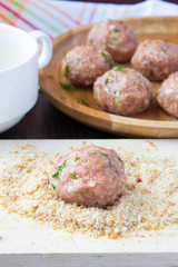 Raw meat balls of minced beef rolled in breadcrumbs