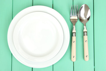 Plate and cutlery on wooden table close-up