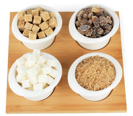 Different types of sugar in bowls isolated on white