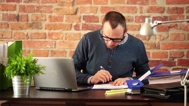 Young man working with documents in modern office
