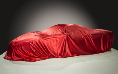 Sportwagen unter einem roten Tuch