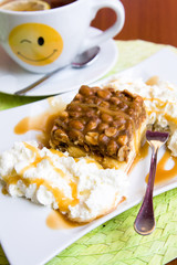 A delicious cake with nuts, whipped cream and caramel