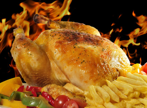 Pollo asado entre llamas