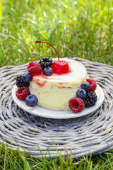 Round vanilla cake decorated with fresh fruits. Garden party.