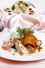 Baked fish in sauce. Dinner in elegant restaurant