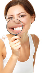 Attractive woman looking through a magnifying glass