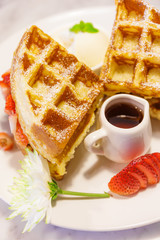 Baked waffles with syrup and strawberries