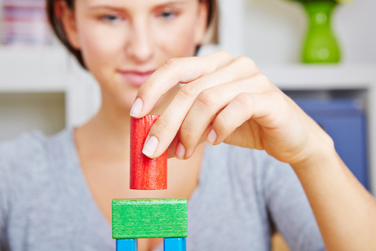 Woman Playing With Wooden Building Bricks