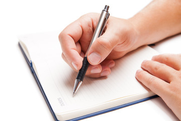 Man hand writing in open book isolated on white