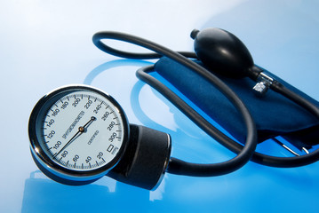 Sphygmomanometer on blue, reflective background