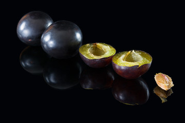 plums on a black glass