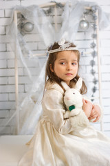 Girl in winter holiday dress with toy rabbit