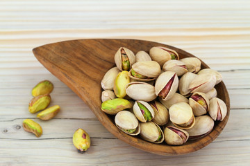 Pistachio nuts with and without shell in wooden bowl