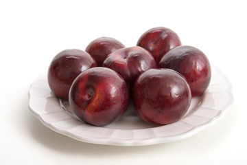 Rote Pflaumen auf einem Teller