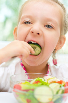 child eating vegetable salad