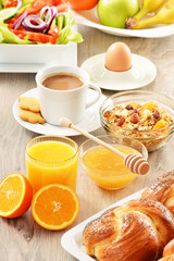 Breakfast including coffee, bread, honey, orange juice, muesli a