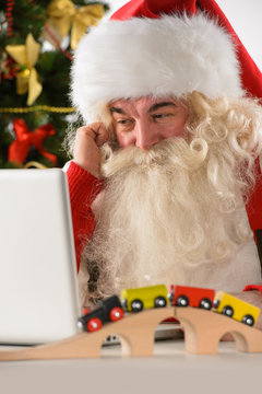 Santa Claus with real beard using laptop