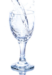 water pouring in a glass on white background.