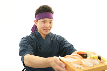 寿司を差し出す笑顔の寿司職人