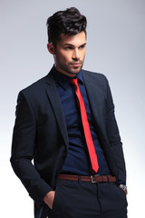 business man looks away with hands in pockets