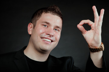 Young man gesturing the ok okay hand sign