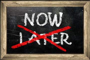 Now or later written with white chalk