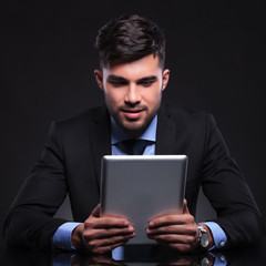 young business man looks at his tablet