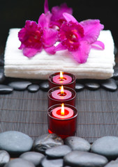 Three candle with orchid with towel, stones at spa