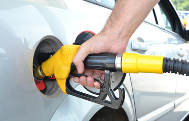 Tanken das Auto mit Diesel. Gelbe Pumpe in der Hand. Steigende Preise auf Benzin.