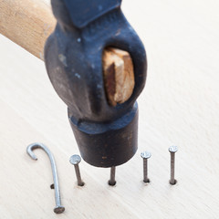 hammer nails into wooden plank