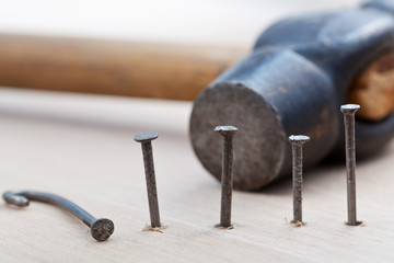 hammer and nails into wooden board