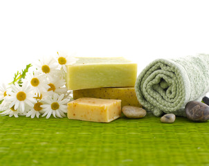 flowers with green towel, soap, stones on green mat