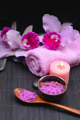 Obraz na płótnie Canvas Beautiful pink orchid on towel and candle, salt in bowl on mat
