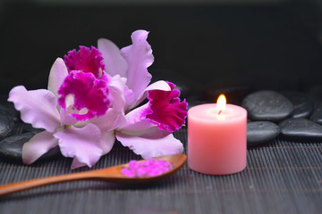 Obraz na płótnie Canvas Beautiful pink orchid and stones ,candle, salt in bowl on mat