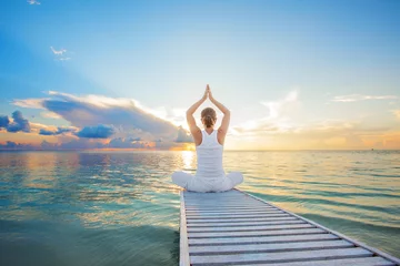 Foto op Plexiglas Blanke vrouw die yoga beoefent aan de kust © Maygutyak