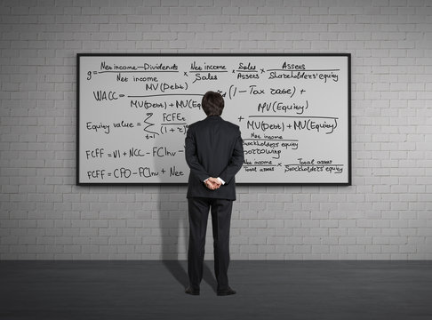 Businessman standing in front of board with formulas