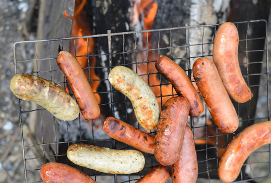 Sausages cooking on a portable barbecue